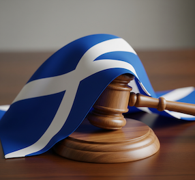 the images shows the scottish flat, a blue background with white cross, draped over an auctioneer's brown wooden gavel