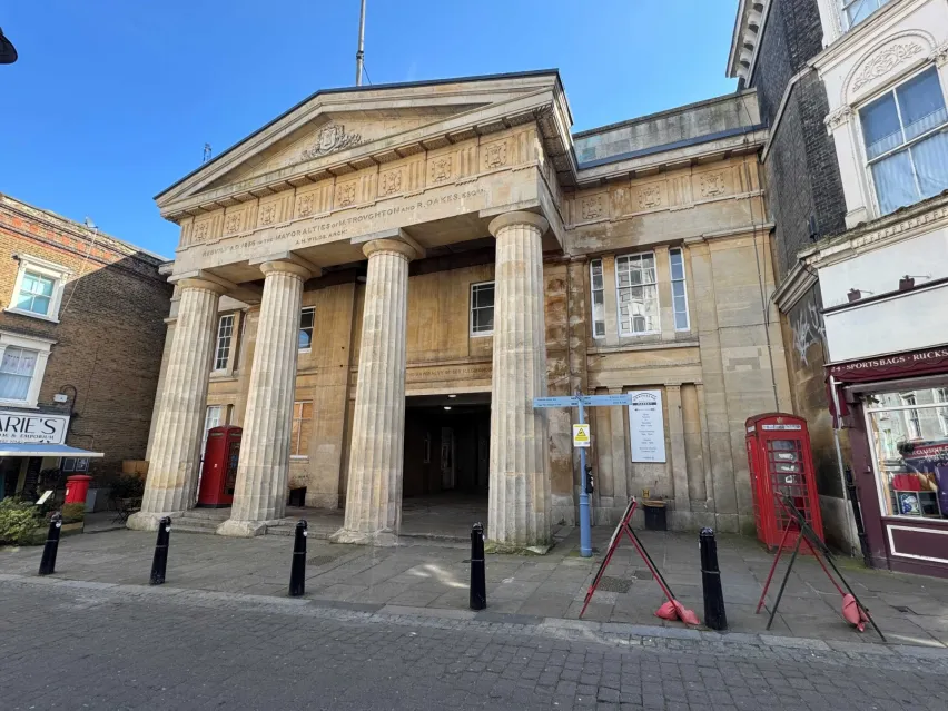 A sandstone Town hall building with four doric columns.