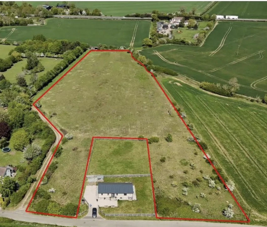 Parcel of green grass land with red outline border to show the extent. Surrounded by more fields and green paddock land.