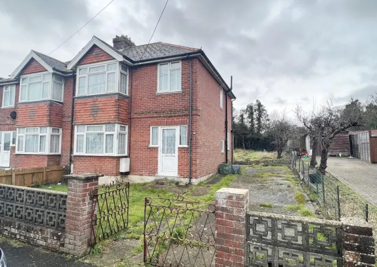 Red brick semi-detached house with bay windows, front garden, and gated driveway.
