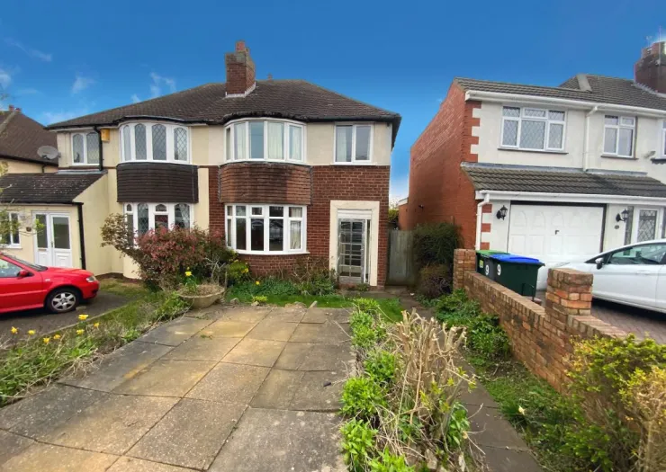 Red brick semi-detached house with bay windows, paved driveway, and front garden.