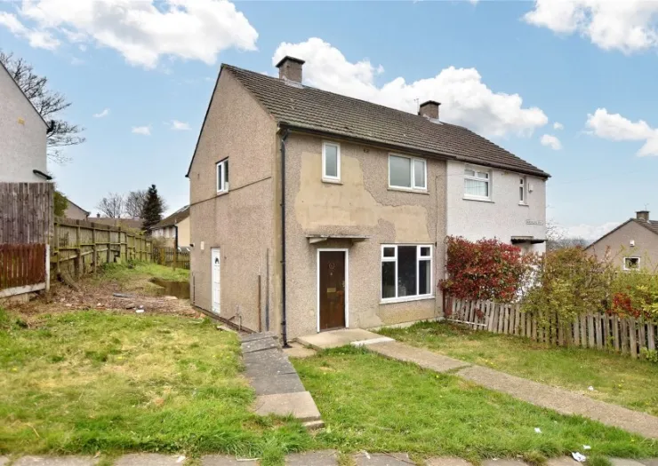 Semi-detached house with front garden and walkway.