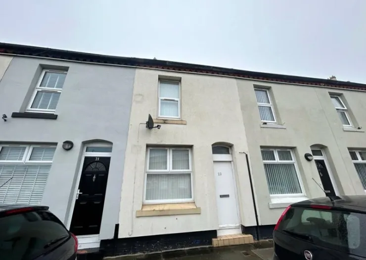 Exterior view of a row of terraced houses with white and grey facades. Number 21 features a black front door.