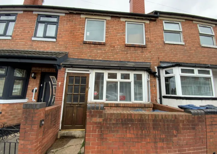 Attached brick house exterior with bay window and wooden front door.