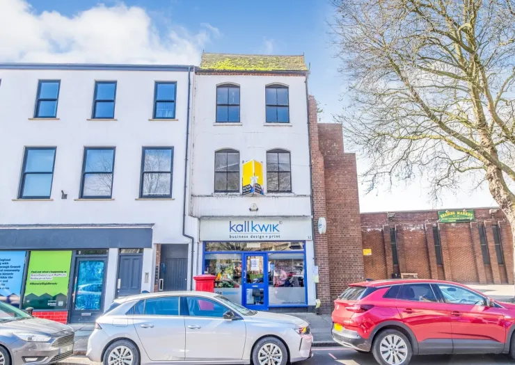 Kallkwik" storefront with white and brick facade on a sunny street.
