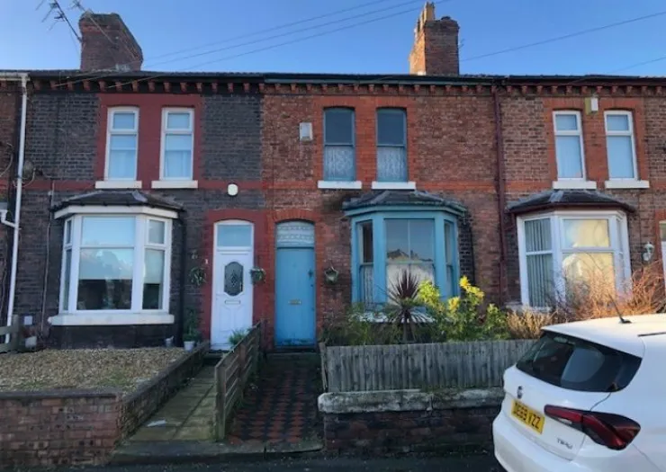 Red brick terraced houses with bay windows and contrasting blue and white doors.