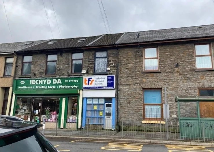 Stone commercial building with "Iechyd Da Healthcare" and "Treherbert Financial Services" storefronts.