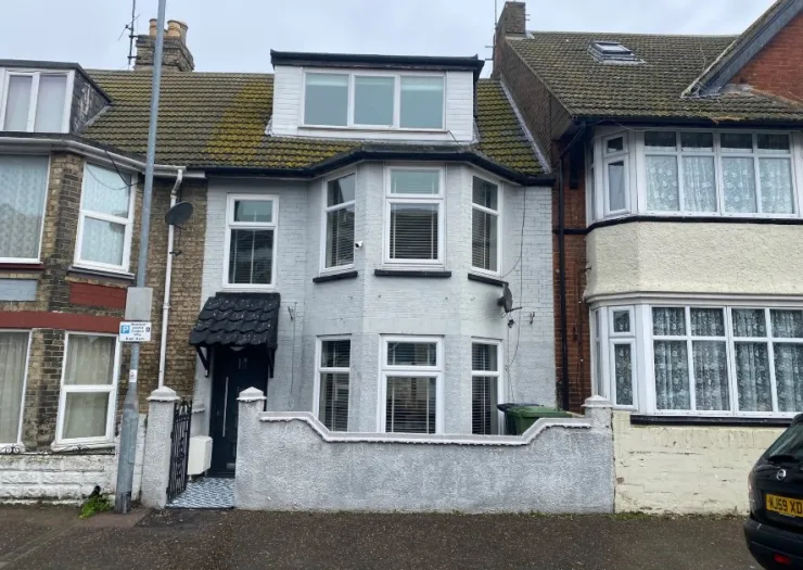 White painted terraced house with bay windows and black porch.