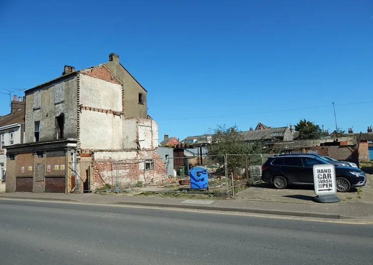 Bright, modern hair salon interior with empty styling stations, wood-look flooring, and wall mirrors.