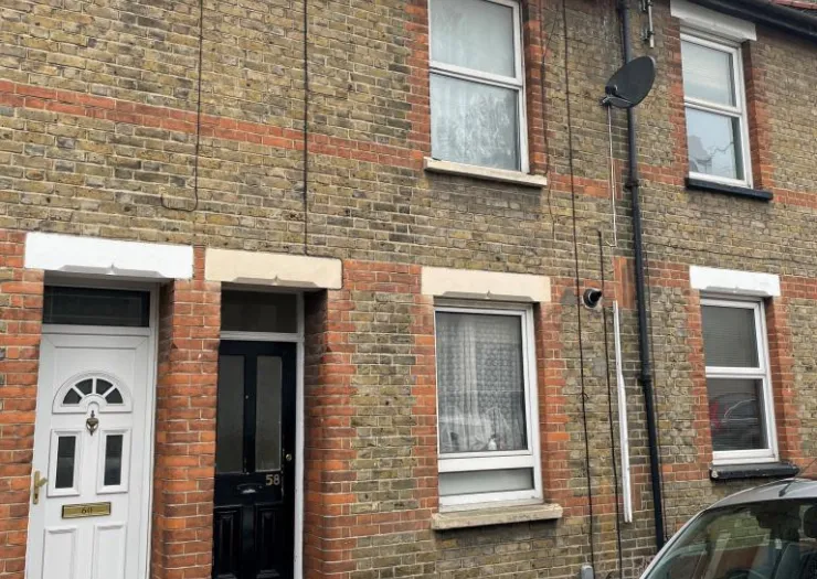 Exterior of terraced brick house with white and black doors, number 58 visible.
