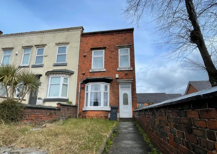 Red brick terraced house exterior with bay window and front garden path.