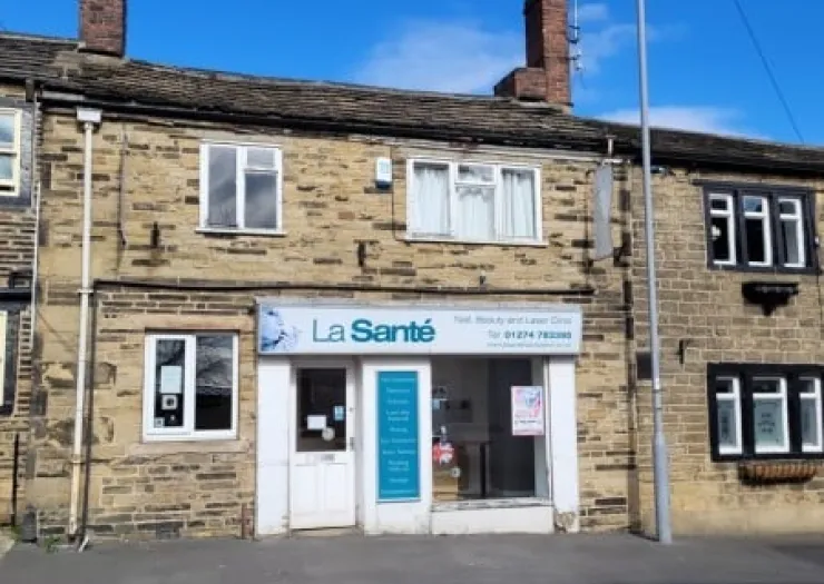 La Santé" beauty and laser clinic storefront in stone building.