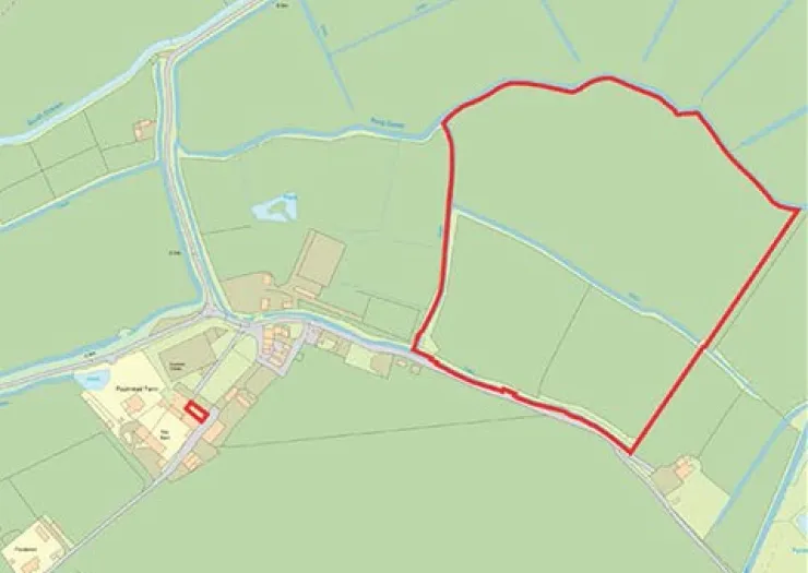 Map outlining a property boundary in red, showing surrounding land, waterways, and nearby buildings.