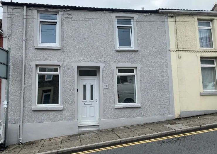 Gray terraced house with white door and windows, number 27.