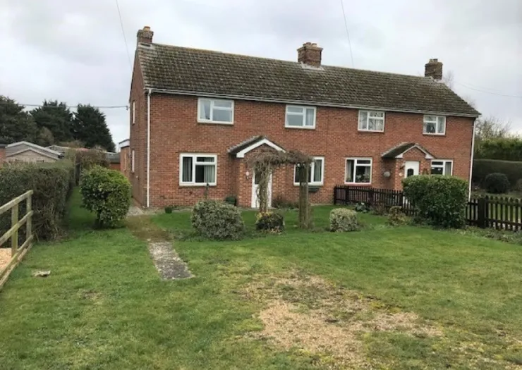 Red brick terraced house with front garden and pathway.