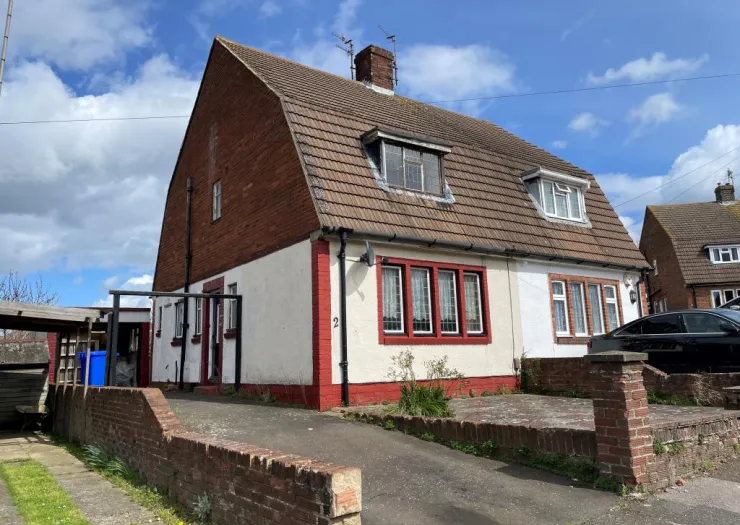 Red brick and white detached house with tiled roof and driveway.