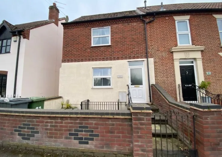 Red brick terraced house exterior with white front door and steps.