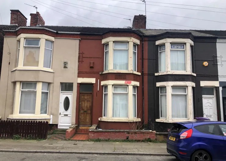 Row of attached terraced houses, various exterior colors, bay windows.