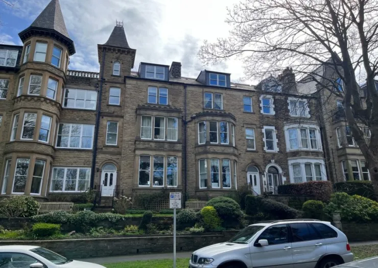 Stone townhouses with turrets, bay windows, and front gardens.
