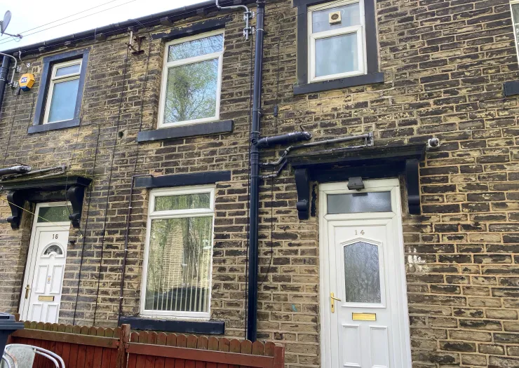 Stone terraced house exterior with white doors, numbered 14 and 16.