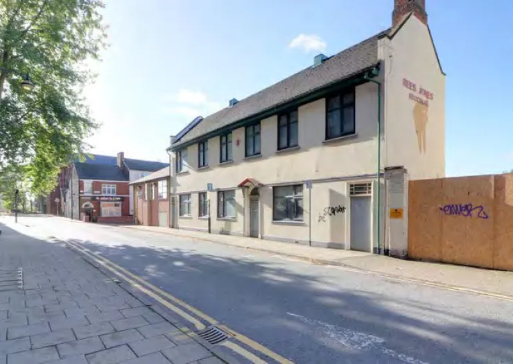 Rees Jones dental surgery exterior, two-story cream building, street view, sunny day.