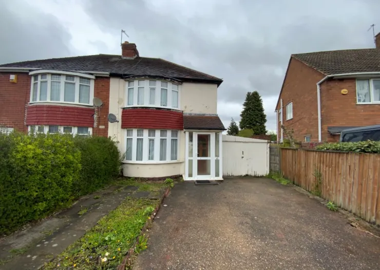 Red-accented semi-detached house with driveway, front garden, and white porch.