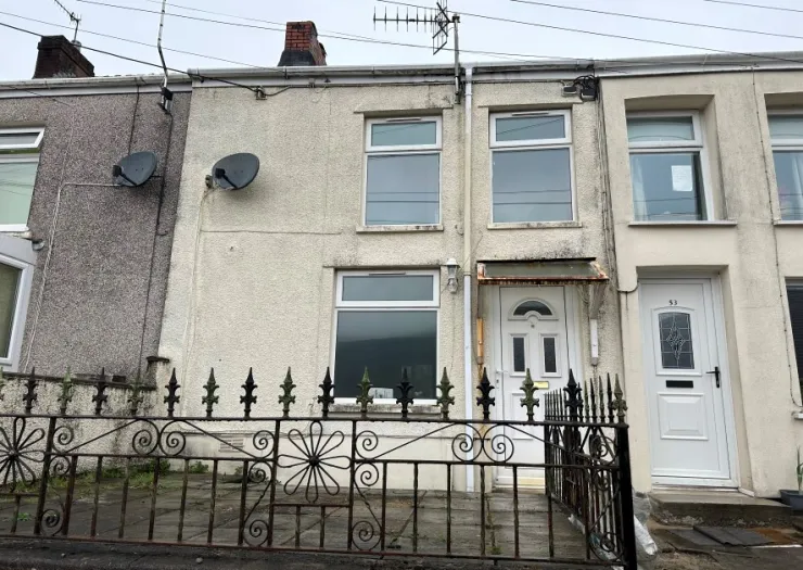 Terraced house exterior with decorative metal fence and white front door.