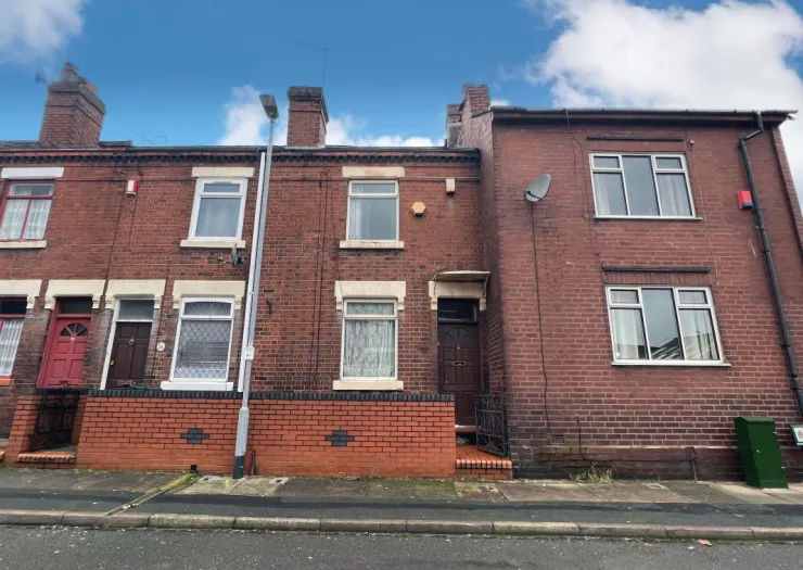 Red brick terraced house exterior with short front garden and wall.