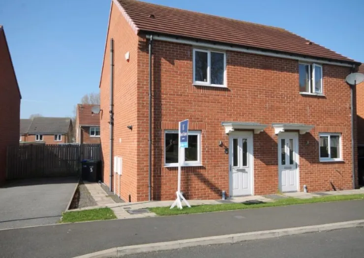 Red brick semi-detached house with "To Let" sign, white doors, and driveway.