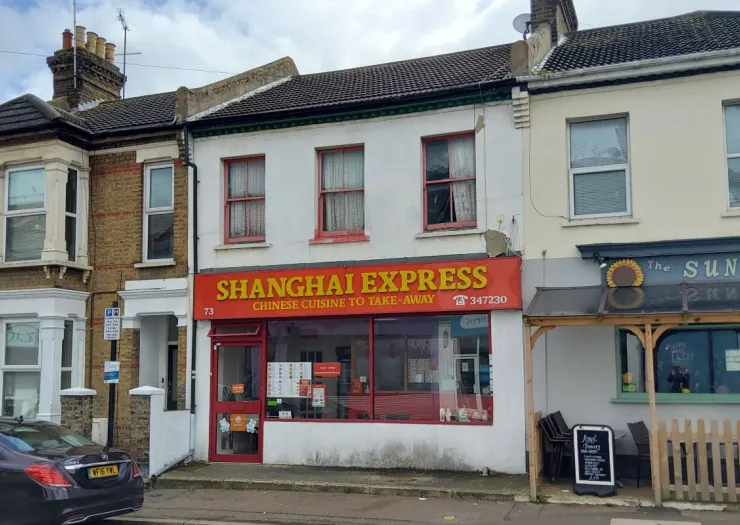 Shanghai Express Chinese takeaway storefront with red signage and visible menu.