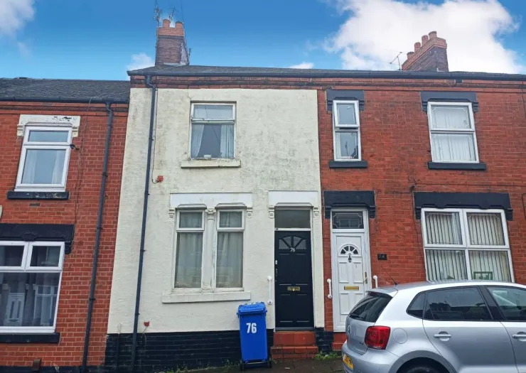 Attached brick house with partially painted facade, black trim, and white doors.