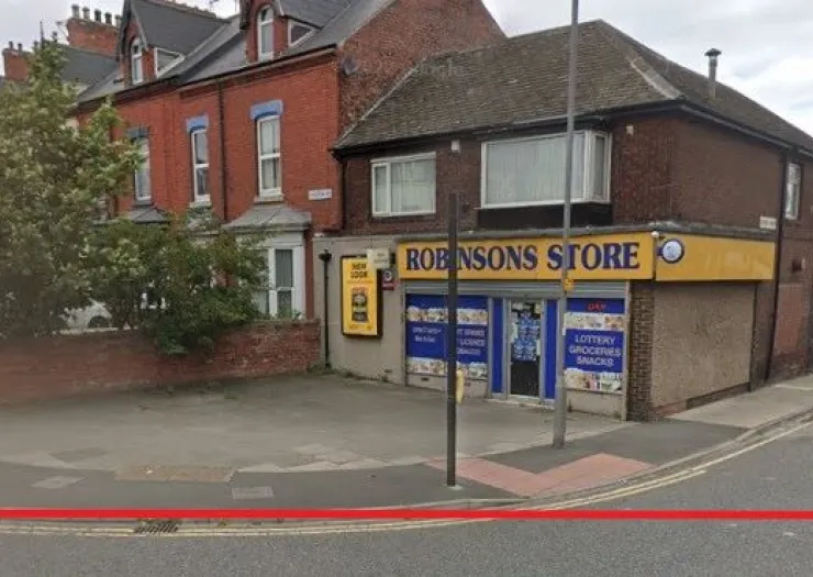Robinsons Store" convenience shop exterior, with brick building and street view.