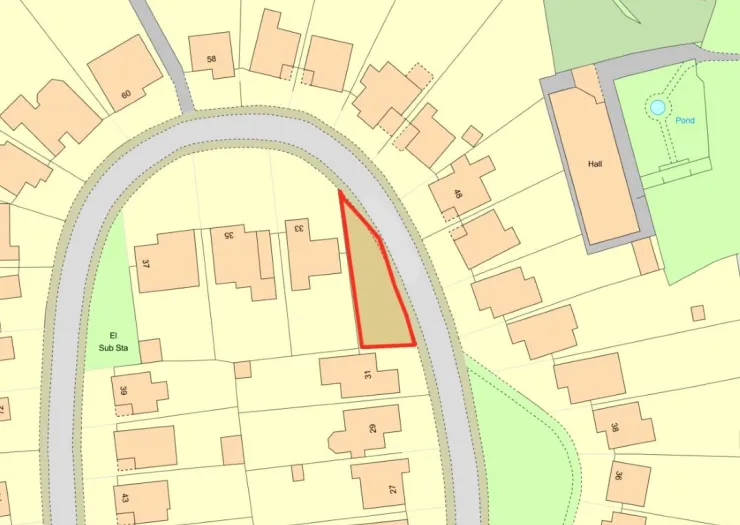 Triangular plot of land highlighted in red on a map, showing adjacent properties and a nearby road.