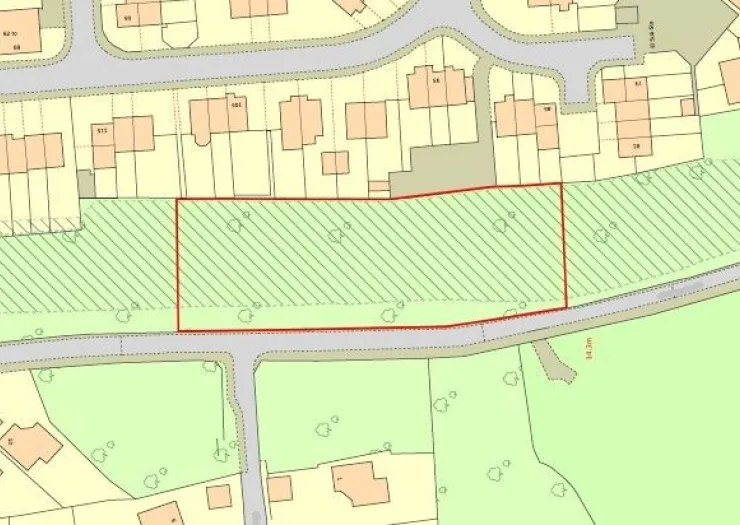 Map outlining a rectangular greenfield area bordered by a road and residential properties.