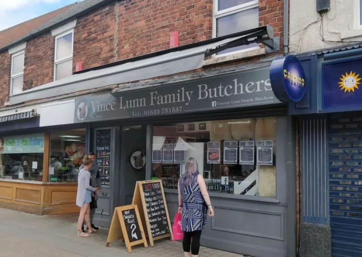Vince Lunn Family Butchers storefront with customers, signage, and daily specials advertised.