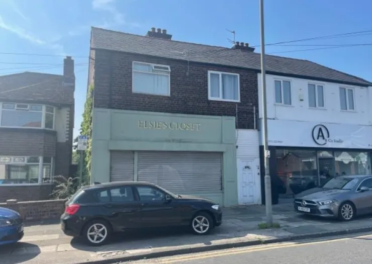 Elsie's Croft" storefront with closed shutters between other businesses on a sunny street.