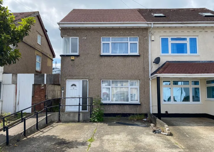 Semi-detached house with ramp access, white front door, and multiple windows.