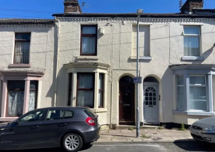 Terraced house exterior with bay windows, white facade, and dark trim.