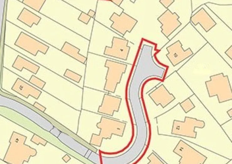Property site map with a red boundary highlighting a curved road and surrounding houses.