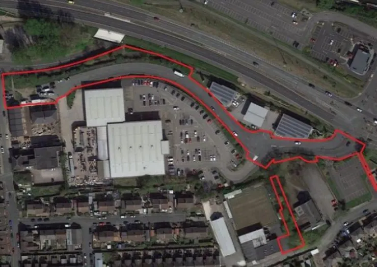 Aerial view of commercial property with red outline marking boundaries, parking lot, and adjacent highway.