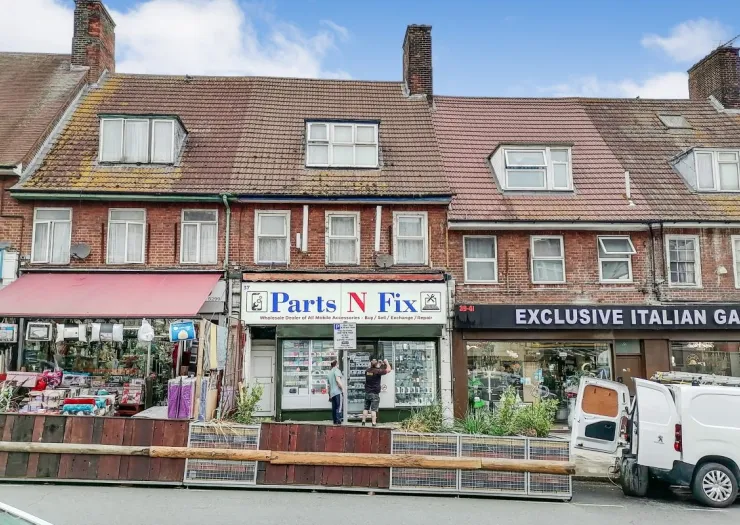 Brick storefront with "Parts N Fix" shop between other businesses.