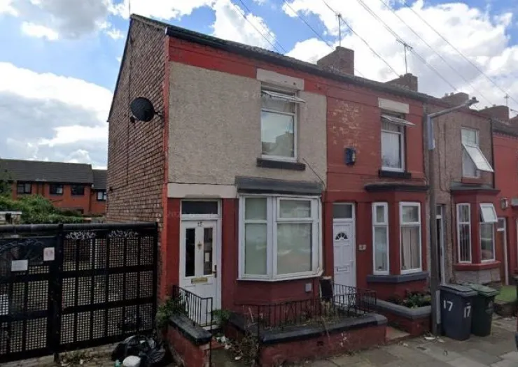 Red brick terraced house with white bay window and front door.