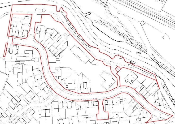 Site plan with red boundary line highlighting buildings, roads, and adjacent mud area.
