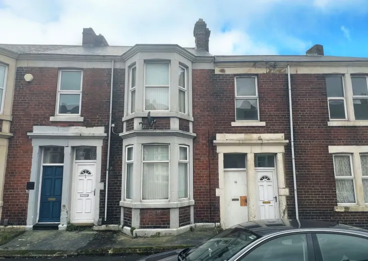 Red brick terraced houses with bay windows and white trim.