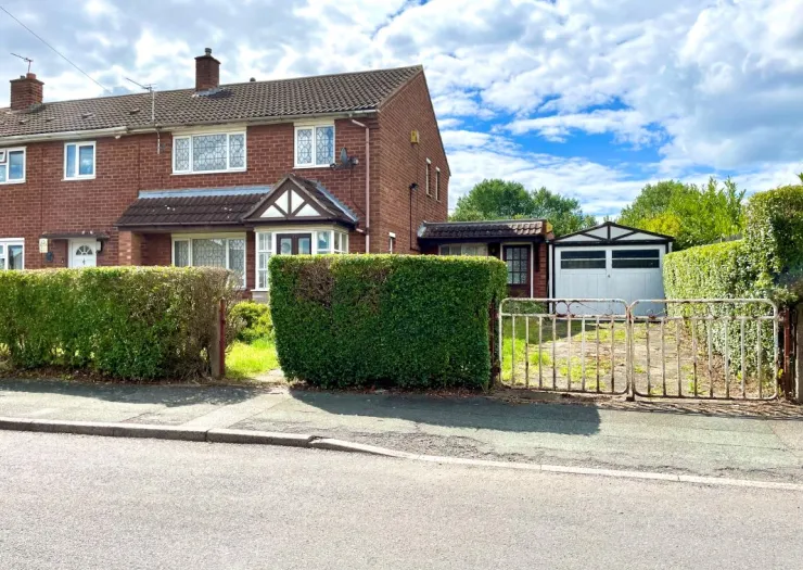 Red brick house with attached garage, front garden, and gated driveway.