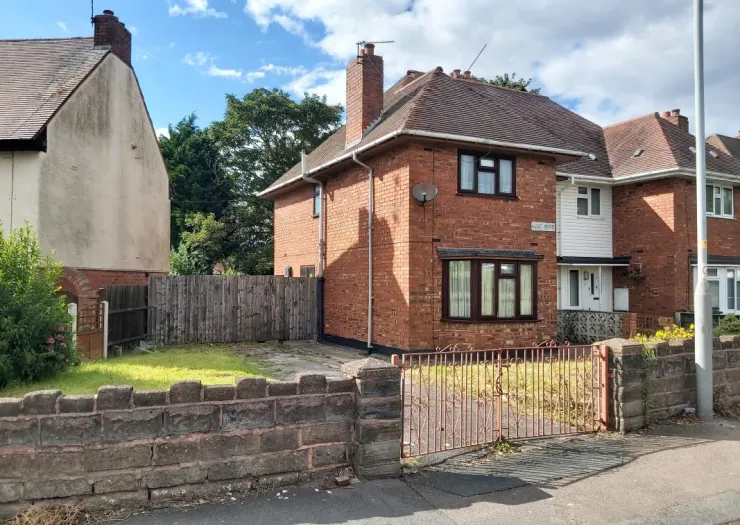 Red brick house with gated driveway and front garden.