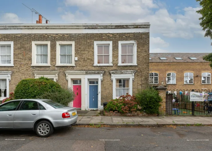 London terraced house with pink and blue doors, viewed from street.