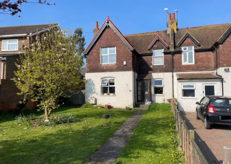 Attached house with red tile roof, front garden, and driveway parking.