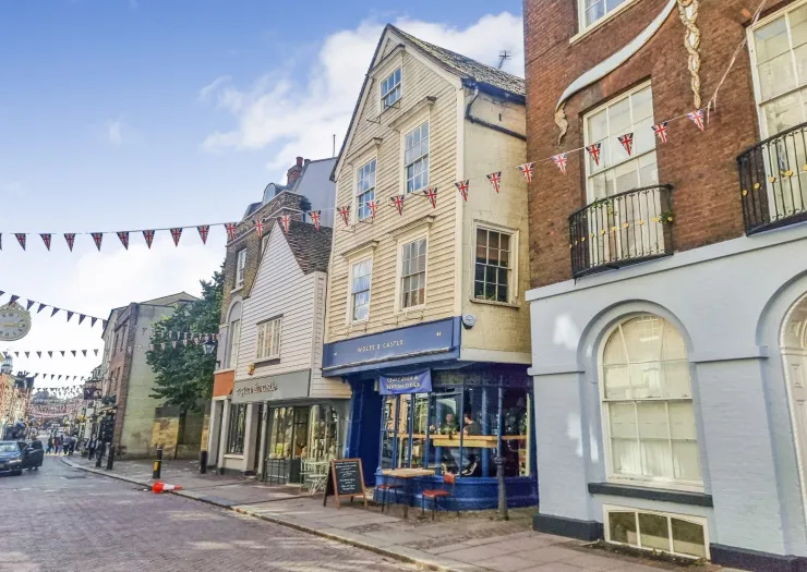 Charming street scene with shops and Union Jack bunting in a historic UK town.