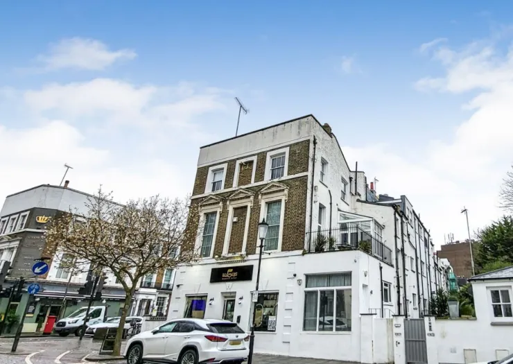 White and brick building with "Salt Craft" signage, street view, parked cars, and blossoming tree.
